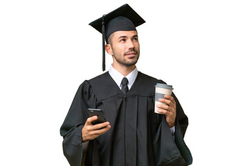 Young university graduate man over isolated background holding coffee to take away and a mobile while thinking something