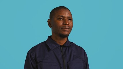 Headshot portrait of african american security agent isolated against colored studio background. Close up shot of guardian securing assigned post standing over studio backdrop, camera B