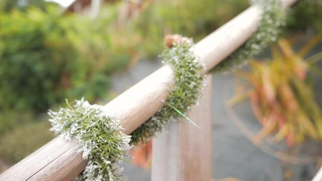 Snowy Christmas garland on wooden railing