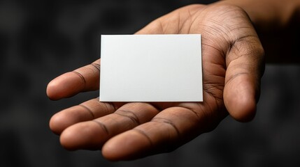 A hand holding a white business card