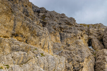 Via ferrata in the Dolomites. Equipped with bridge and steel cable hiking and climbing path in the high rocky mountains in Dolomiti Alps. Historical and extreme passages between the mountain cliffs an
