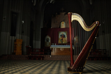 Background shot of elegant harp with wooden frame captured in dimly lit church, copy space