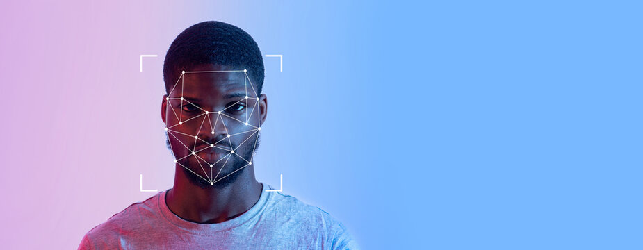 Man is engaged in facial recognition technology. His face is highlighted by a grid overlay, which signifies identification processes in a high-tech context.