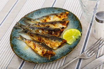 Appetizing fried sardines with golden skin served slice of lemon, perfect for nutritious healthy dining option