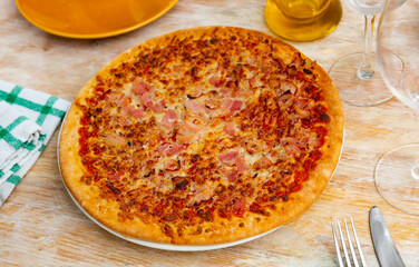 Pizza from the oven with mozzarella cheese, tomatoes and jamon