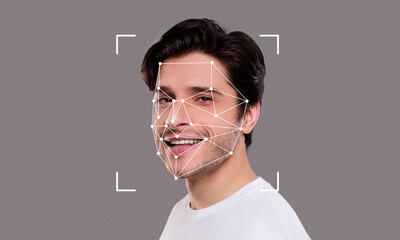 A young man smiles while facial recognition technology analyzes his features. The digital overlay highlights key facial points for identification.