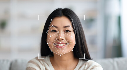 A woman with long hair smiles at the camera while facial recognition technology analyzes her...