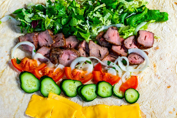 Delicious wrap preparation with fresh ingredients and savory meat