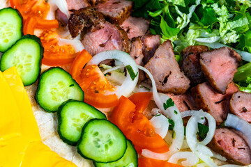 Delicious meat platter with fresh vegetables and herbs for a vibrant meal