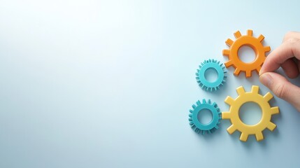Hand holding colorful gears on blue background, a visual representation of innovation and creativity