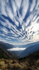 Obraz premium Breathtaking View of a Majestic Mountain Range with Still Clouds and Dramatic Sky, Showcasing Nature's Splendor in a Serene Landscape