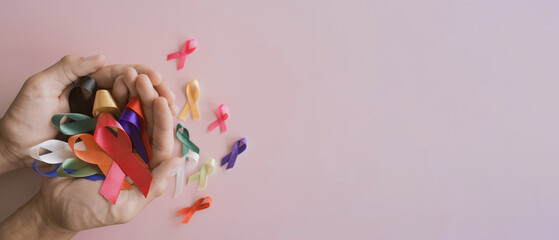 Hands holding color ribbons, world cancer day, World Autism Awareness Day concept
