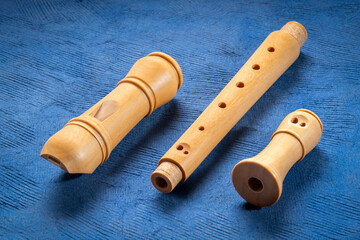 Fototapeta premium components of wooden recorder flute instrument, classic German style, against textured art paper