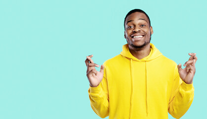 Wish Me Luck. African American Guy Keeping Fingers Crossed Smiling To Camera Posing In Studio Over...