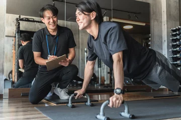 Fotobehang Persoonlijk スポーツジムでパーソナルトレーニングを受ける若いアジア人男性   © buritora