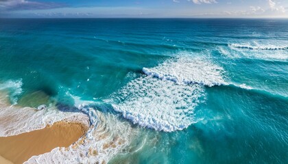 aerial view of turquoise ocean waves crashing on sandy beach