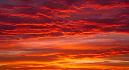 Obraz premium The sky at sunset is embellished with abstract patterns of red and orange clouds, radiating warmth.