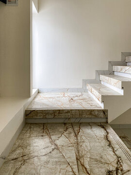Elegant marble stairs with sunlight coming through the window, creating a calm and modern atmosphere.