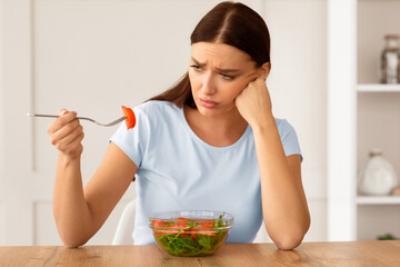 Healthy Diet. Sad Girl Eating Fresh Vegetable Salad Slimming And Losing Weight Sitting At Dinner...