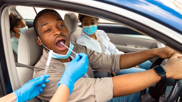 African American Family Getting Tested For Covid-19 Sitting In Car, Wearing Protective Face Masks. Drive-Thru Covid Testing Site Concept. Coronavirus Diagnostic, Pandemic Outbreak - Powered by Adobe