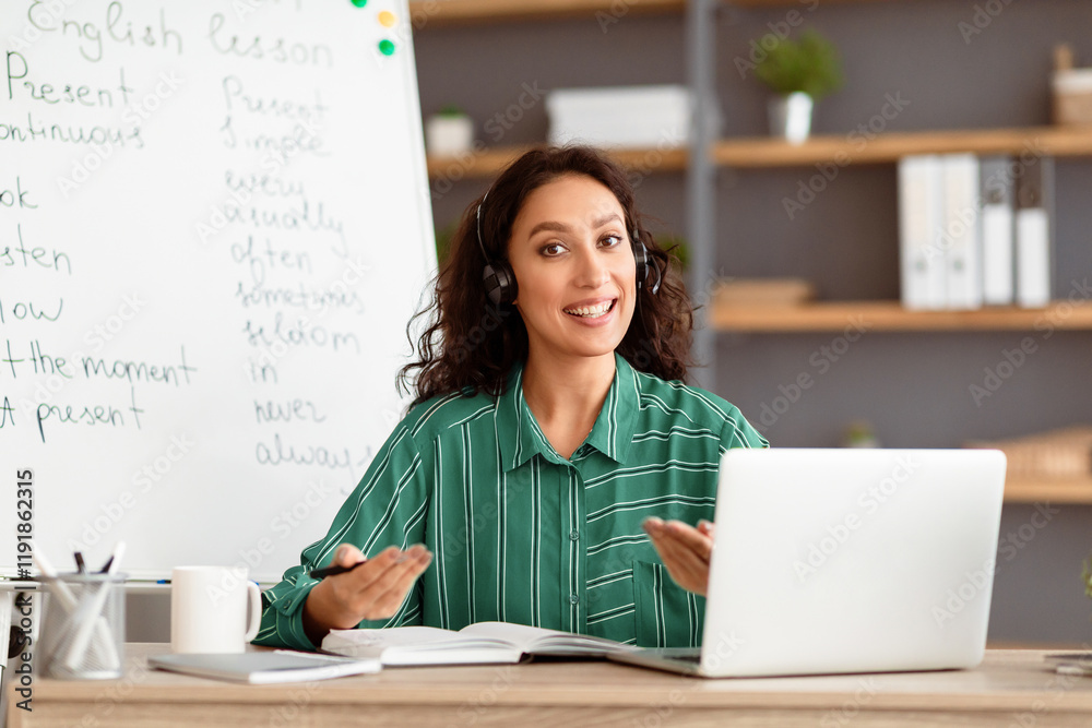 Poster distant learning concept. portrait of smiling teacher talking and gesturing to camera wearing wirele