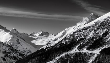 Obraz premium A breathtaking black-and-white landscape showcasing snow-covered mountains under a clear sky, highlighting the beauty of winter and nature's grandeur.