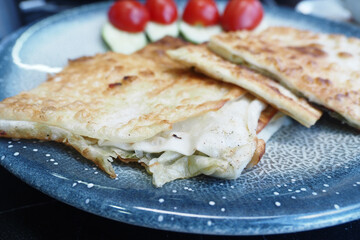 A Delectable CheeseStuffed Flatbread Accompanied by Fresh Vegetables