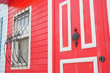 This is a vibrant red door that features attractive decorative window grills