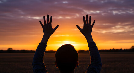 Fototapeta premium An open concept featuring hands uplifted, capturing sunlight against a backdrop of a sunset sky. 