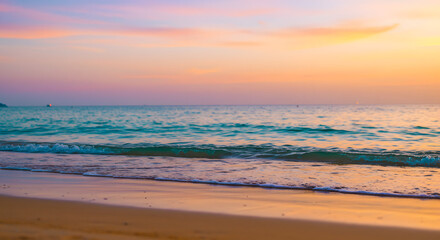 Fototapeta premium At Golden Shores, the fine sand merges with the indistinct waves, all set against a brilliant tropical sunset backdrop.