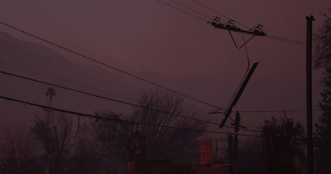 Altadena, California, USA - January 8, 2025: Power lines destroyed by the Eaton Fire hang in a residential neighborhood.