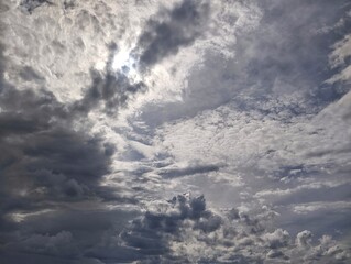 Obraz premium Dramatic dark clouds with Sun shining behind, Irregular clouds in darkening sky before rainfall on a spring evening, for themes of transition