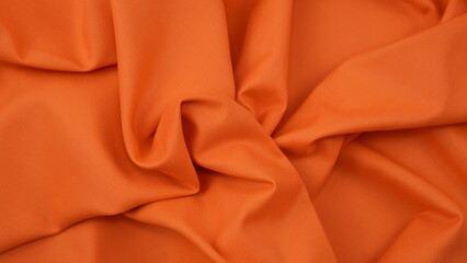 Obraz premium Close-up of orange cotton fabric showing a detailed woven texture, soft natural fibers, and a smooth textile surface perfect for design or background use.