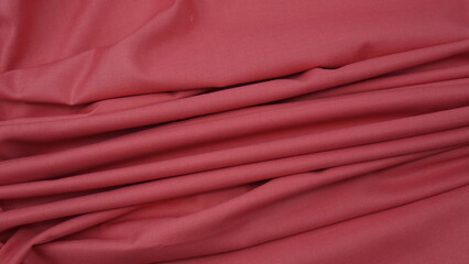 Close-up of rouge pink cotton fabric showing a detailed woven texture, soft natural fibers, and a smooth textile surface perfect for design or background use.