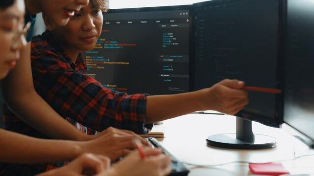 Slow motion back end software developer engineer for computer programming working together on debugging writing computing code, solving complex algorithms display on monitor in office. Burgeoning