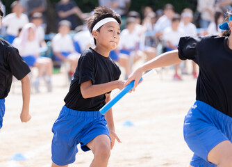 運動会でリレーを走る小学生の男の子