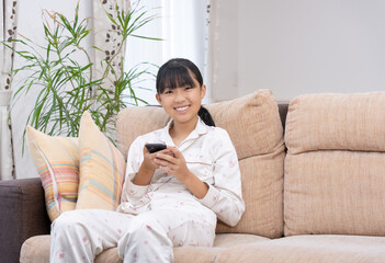 Obraz premium パジャマでスマホを見ている女子中学生 朝