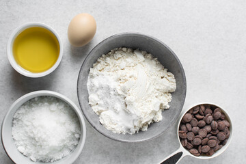 overhead view of mise en place for homemade chocolate chip cookies, ingredients for making chocolate chip cookies on a marble countertop	