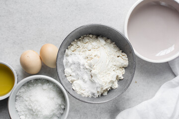 overhead view of mise en place for homemade chocolate chip cookies, ingredients for making chocolate chip cookies on a marble countertop