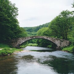 Fototapeta premium Tranquil river crossing at an ancient stone bridge serene landscape nature photography lush green environment captured in soft light