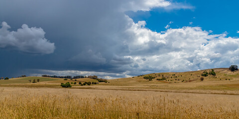 Fototapeta premium Countryside and storm clouds with blue sky