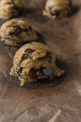 scoops of chocolate chip cookie dough on a baking sheet, homemade chocolate chip cookie dough, process of making chocolate chip cookies