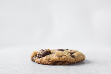 Large chocolate chip cookies on a white countertop, top view of homemade chocolate chip cookies on a white background