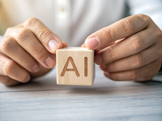 man's hand holding wooden cube with AI inscription
