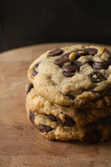 Large chocolate chip cookies on a wood tray, top view of homemade chocolate chip cookies