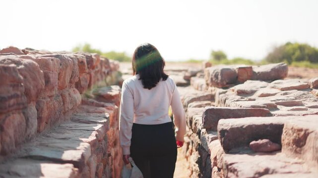 Indian woman exploring ruins of Dholavira Harappan Civilization at Kutch, Gujarat, India. The ancient city of Dholavira UNESCO World Heritage Centre.Travel and exploration concept