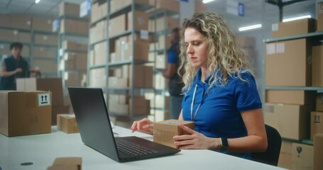 Female inventory manager scans parcels with barcode scanner, prepares for shipping to customers, works on laptop. Warehouse employees checking boxes for shipping. E-commerce store or postal service.