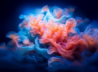 Abstract image of swirling, vibrant blue and coral inks against a dark background. The colors blend and create a mesmerizing, organic form.