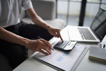 Man using calculator calculate finance and another hand holding pen
