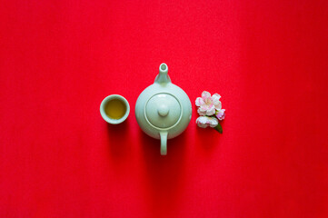 Tea set and peach blossom on red cloth background for Chinese new year concept.